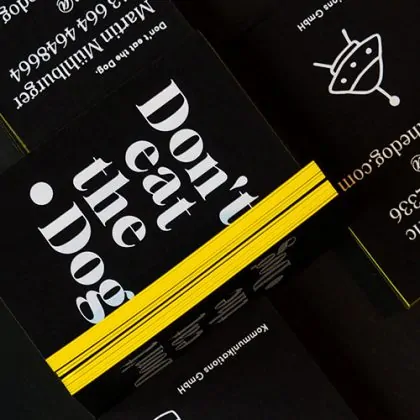 schwarze Visitenkarten mit gelber Schnittkante und weißer Heißfolie